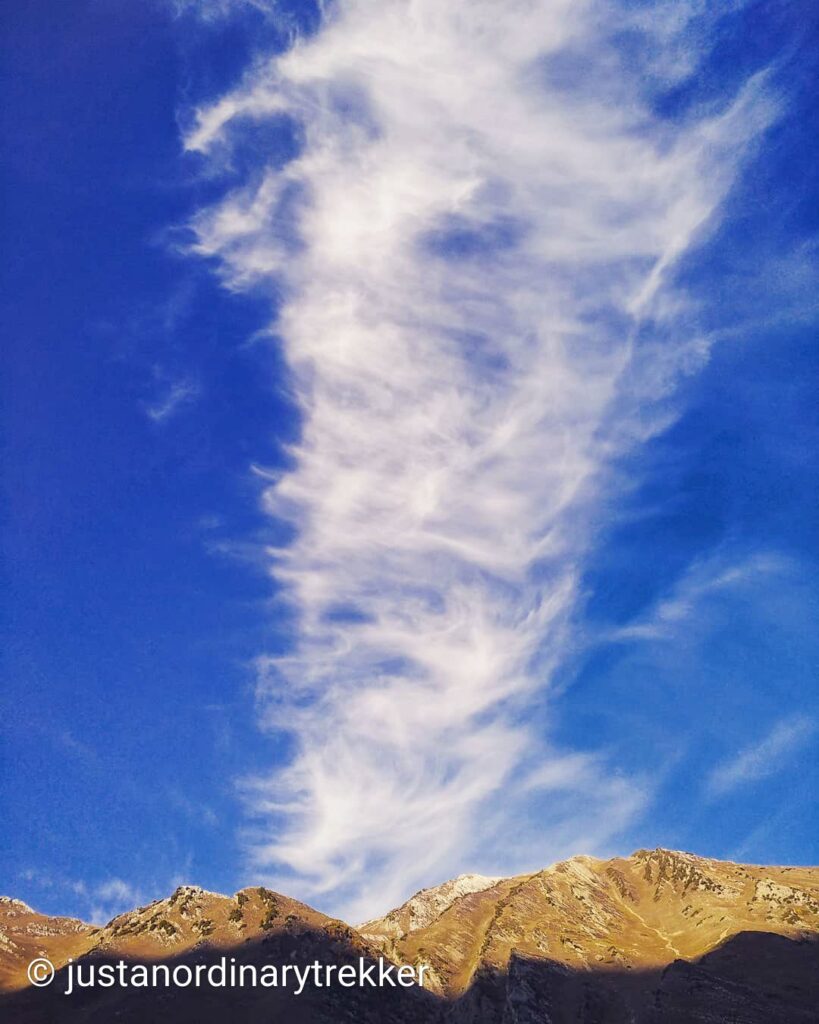 Morning view from Gadsar Camp on the Kashmir Great Lakes Trek with clouds drifting over the surrounding Himalayan mountains.